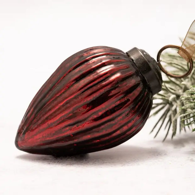 Red glass Christmas ornament with ribbed texture on a white background
