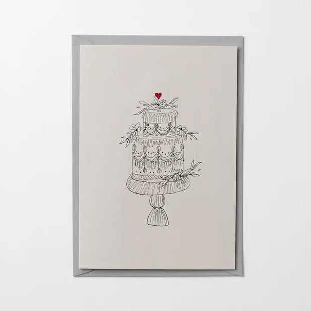 Framed artwork of a three-tiered cake with a heart on top, on a white background.