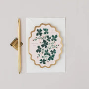 Decorative card with floral design and gold accents on a light gray background