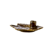 Ceramic candle holder with leaf design on a white background