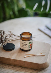 Aery Tomato Leaf candle on a wooden surface with a natural background