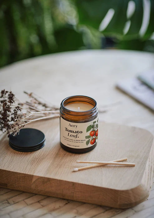 Aery Tomato Leaf candle on a wooden surface with a natural background