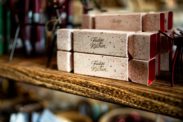 Boxes of Fudge Kitchen fudge on a wooden shelf with a blurred background - from Victoria Shop