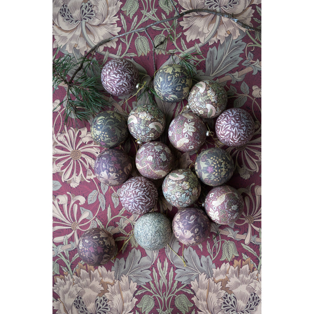 Decorative Christmas baubles with floral patterns on a floral-patterned fabric background