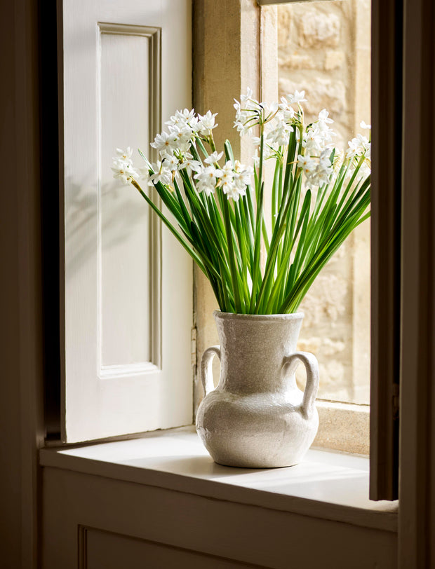 White flowers in a vase on a windowsill