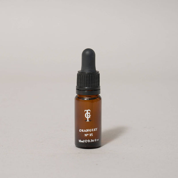 Brown glass dropper bottle with black cap on a light gray background