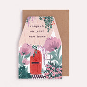 Greeting card with floral design and text 'congrats on your new home' on a brown envelope.