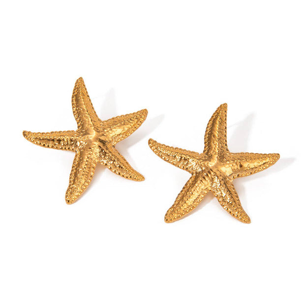 Gold starfish earrings on a white background