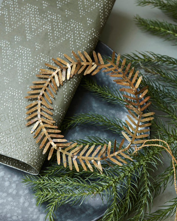 Metal Twig Leaf Hanging Circle Decoration displayed on christmas gift wrap