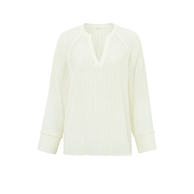 A supple top crafted from cotton and styled with a V-neck, long sleeves and fringe details. Ivory white