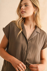 Woman wearing a brown shirt against a beige background, Miou Muse