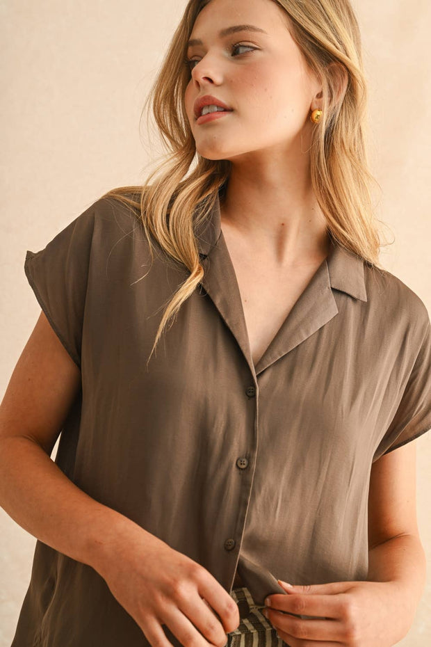 Woman wearing a brown shirt against a beige background, Miou Muse