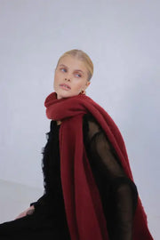 Woman wearing a red scarf against a white background