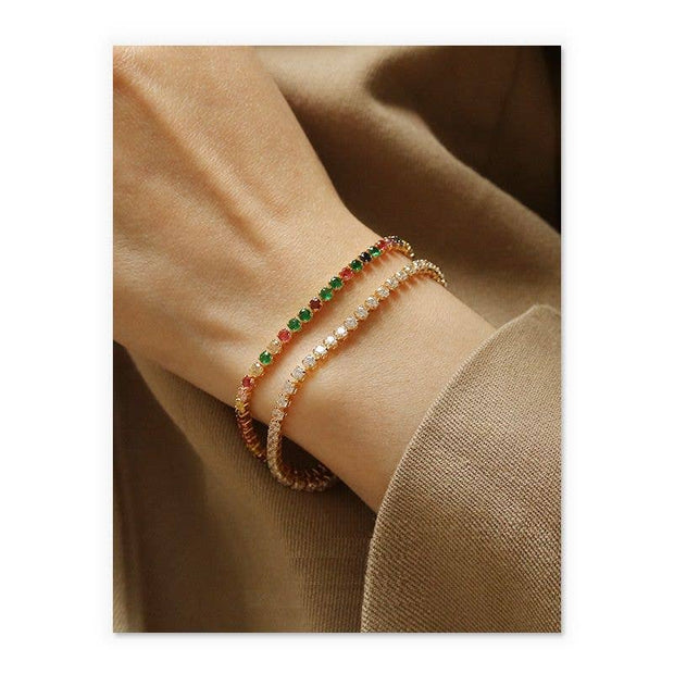 Close-up of a wrist wearing two beaded bracelets on a beige background