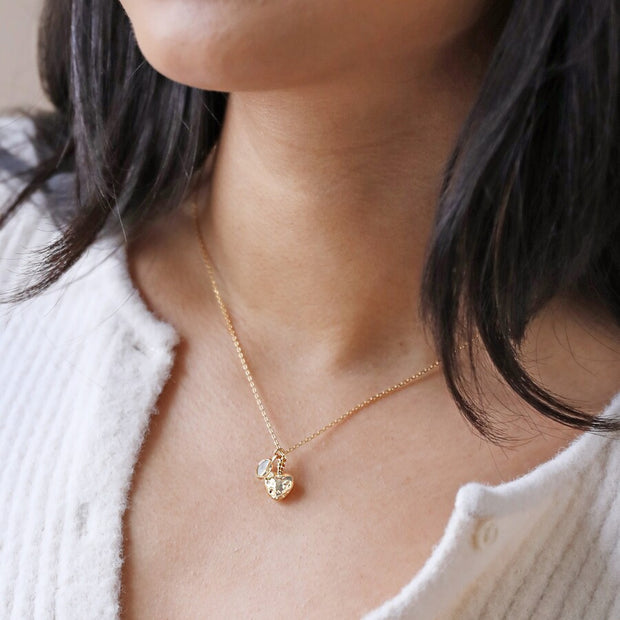 model wearing heart and moonstone gold necklace