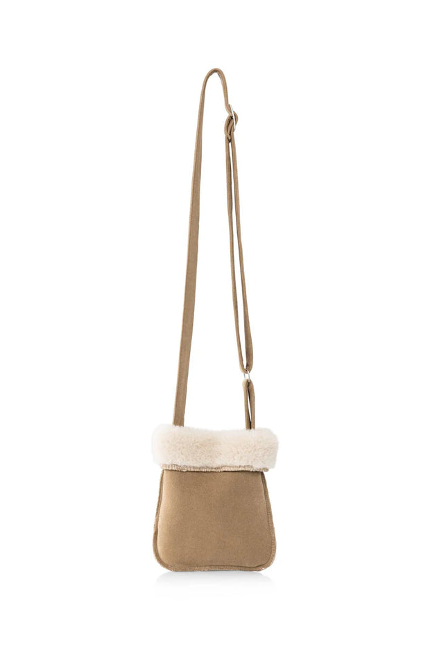 Small crossbody bag with beige body and white fur trim on a white background