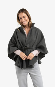 Woman wearing a gray poncho on a white background