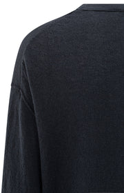detail of navy long-sleeve sweater on a white background