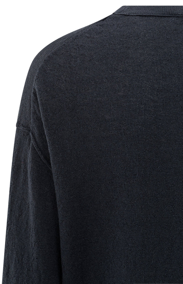 detail of navy long-sleeve sweater on a white background