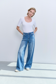 model wearing high waisted wide leg denim jeans